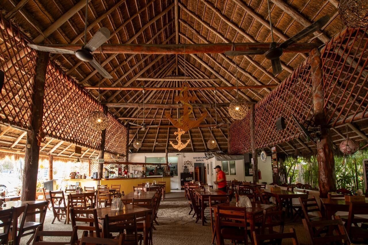Hotel El Capitán Tulum: palapa-roofed restaurant with wooden tables