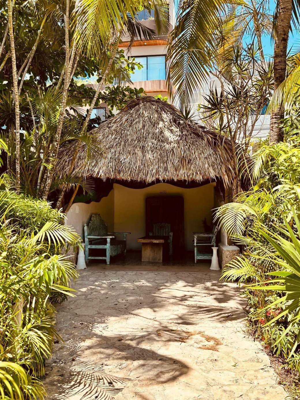Hotel El Capitán Tulum: small palapa with a bench and table in the garden